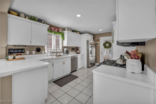 9013 Elsmere Dr, Parma, OH 44130 - kitchen featuring appliances with stainless steel finishes, white cabinets, light countertops, light tile patterned floors, and a peninsula