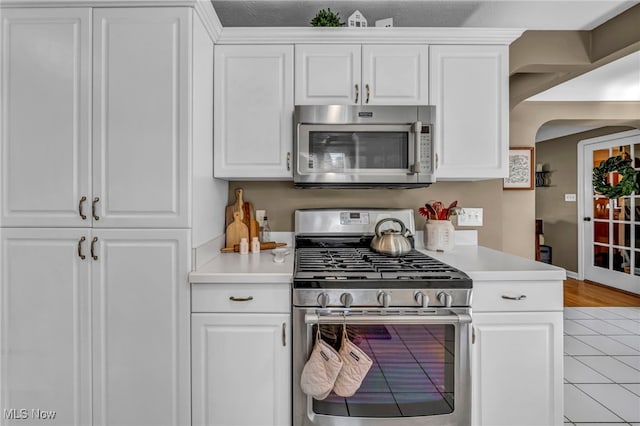 9013 Elsmere Dr, Parma, OH 44130 - kitchen featuring appliances with stainless steel finishes, light countertops, white cabinets, and light tile patterned floors