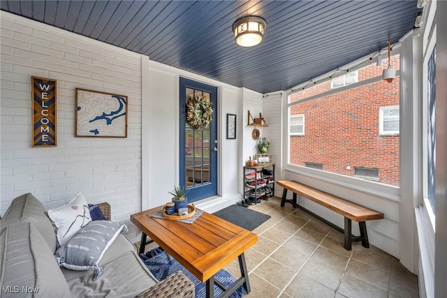 9013 Elsmere Dr, Parma, OH 44130 - living area featuring brick wall, plenty of natural light, and tile patterned floors