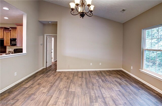 9111 Devonshire Dr, Olmsted Falls, OH 44138 - spare room featuring wood finished floors, a chandelier, recessed lighting, and vaulted ceiling