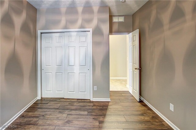 9111 Devonshire Dr, Olmsted Falls, OH 44138 - unfurnished bedroom featuring dark wood-style flooring and a closet