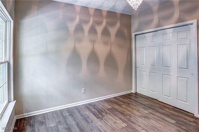 9111 Devonshire Dr, Olmsted Falls, OH 44138 - unfurnished bedroom featuring dark wood-style flooring, a closet, and a chandelier