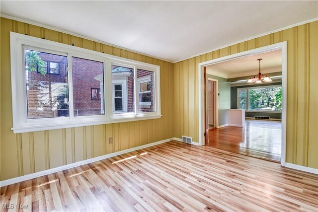 2607 Ashurst Rd, University Heights, OH 44118 - unfurnished room featuring a chandelier, ornamental molding, and wood finished floors
