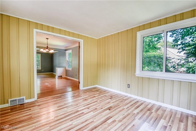 2607 Ashurst Rd, University Heights, OH 44118 - empty room with a chandelier, crown molding, and light wood-type flooring