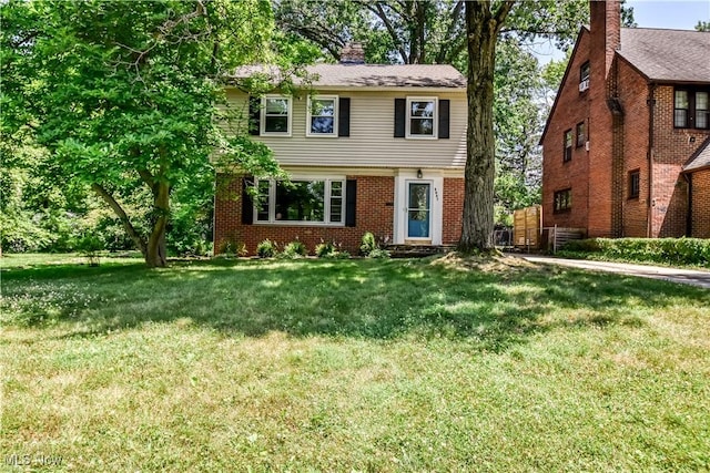 2607 Ashurst Rd, University Heights, OH 44118 - colonial-style house featuring a front yard, a chimney, and brick siding