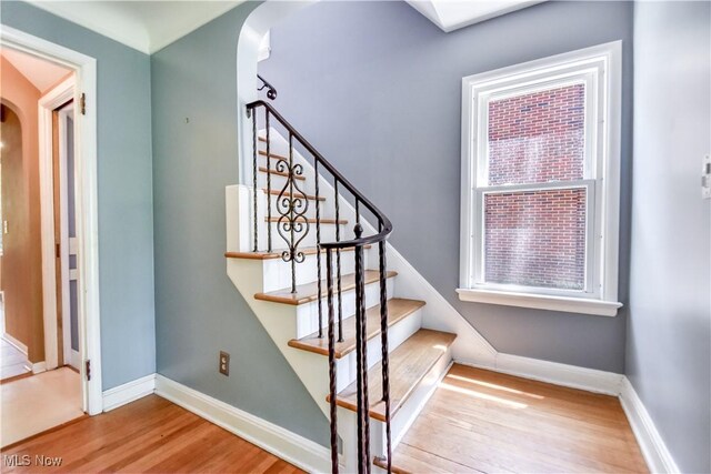 2607 Ashurst Rd, University Heights, OH 44118 - stairway featuring arched walkways, wood finished floors, and healthy amount of natural light