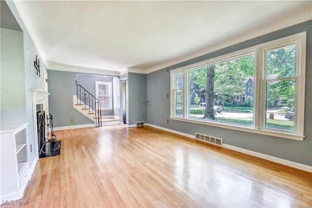 2607 Ashurst Rd, University Heights, OH 44118 - unfurnished living room featuring light wood-style floors, stairs, and a fireplace