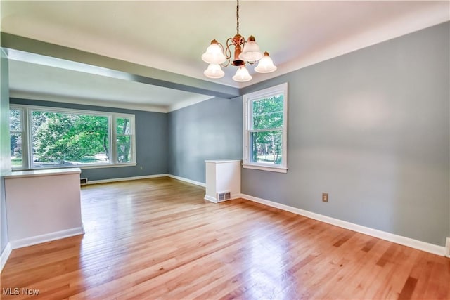 2607 Ashurst Rd, University Heights, OH 44118 - unfurnished room with plenty of natural light, wood finished floors, and a chandelier