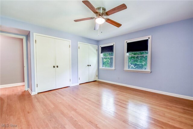 2607 Ashurst Rd, University Heights, OH 44118 - unfurnished bedroom featuring multiple closets, wood finished floors, and a ceiling fan