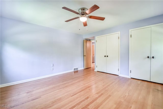 2607 Ashurst Rd, University Heights, OH 44118 - unfurnished bedroom featuring multiple closets, light wood-style floors, and ceiling fan