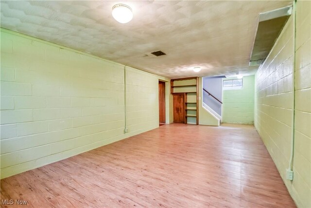 2607 Ashurst Rd, University Heights, OH 44118 - empty room with wood finished floors, stairs, and concrete block wall