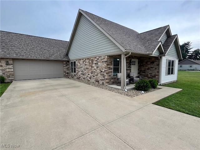 507B Memory Ln, Bethesda, OH 43719 - view of property exterior with a garage, roof with shingles, concrete driveway, stone siding, and a yard