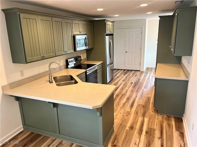 507B Memory Ln, Bethesda, OH 43719 - kitchen featuring appliances with stainless steel finishes, a peninsula, light wood finished floors, light countertops, and recessed lighting