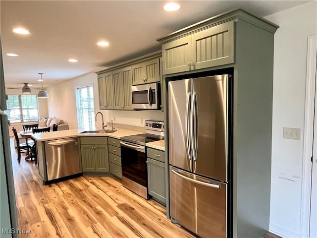 507B Memory Ln, Bethesda, OH 43719 - kitchen featuring stainless steel appliances, green cabinets, recessed lighting, a peninsula, and light wood-type flooring