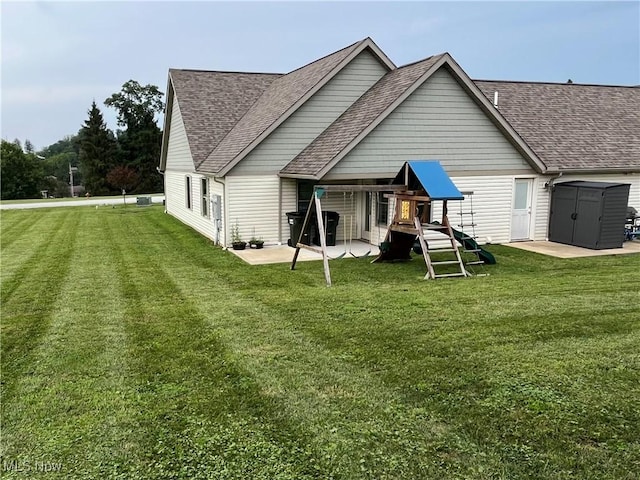 507B Memory Ln, Bethesda, OH 43719 - rear view of property with a playground, a lawn, a shingled roof, and a patio