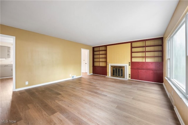 1005 Fairview Blvd, Coshocton, OH 43812 - unfurnished living room featuring a fireplace with flush hearth, light wood finished floors, and built in shelves