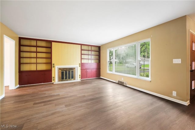 1005 Fairview Blvd, Coshocton, OH 43812 - unfurnished living room with wood finished floors, a glass covered fireplace, and built in features