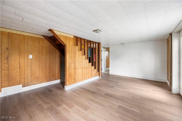 1005 Fairview Blvd, Coshocton, OH 43812 - unfurnished living room featuring wood finished floors, wooden walls, and stairs