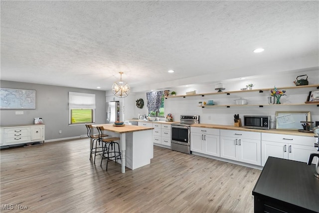 3111 Serfass Rd, New Franklin, OH 44216 - kitchen with wooden counters, stainless steel appliances, open shelves, a textured ceiling, and light wood-type flooring