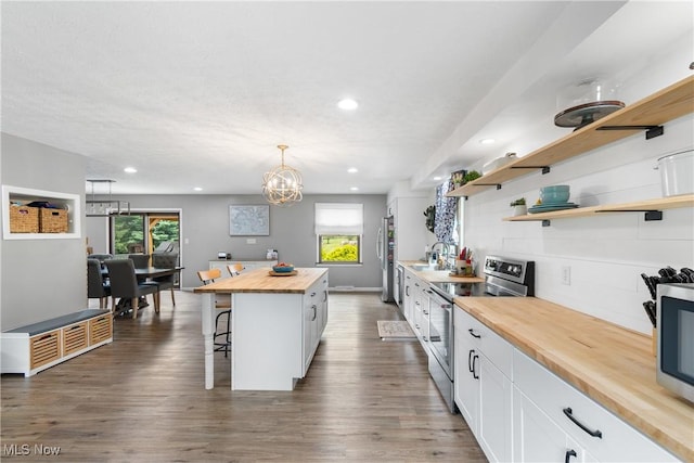 3111 Serfass Rd, New Franklin, OH 44216 - kitchen featuring butcher block counters, appliances with stainless steel finishes, a kitchen breakfast bar, white cabinets, and recessed lighting