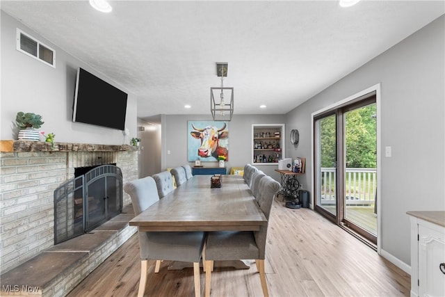 3111 Serfass Rd, New Franklin, OH 44216 - dining area with wood finished floors, a brick fireplace, and recessed lighting