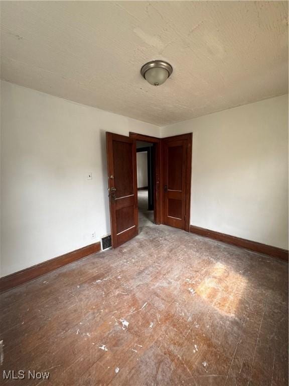 3038 E 130th St, Cleveland, OH 44120 - spare room featuring baseboards and a textured ceiling