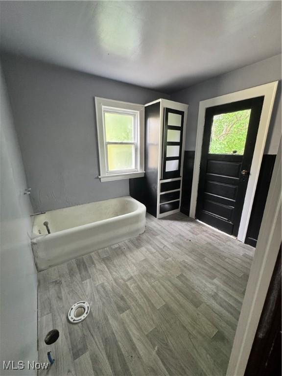 3038 E 130th St, Cleveland, OH 44120 - bathroom with a freestanding tub, wood finished floors, and healthy amount of natural light