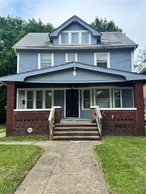 3038 E 130th St, Cleveland, OH 44120 - american foursquare style home featuring covered porch, brick siding, and a front lawn