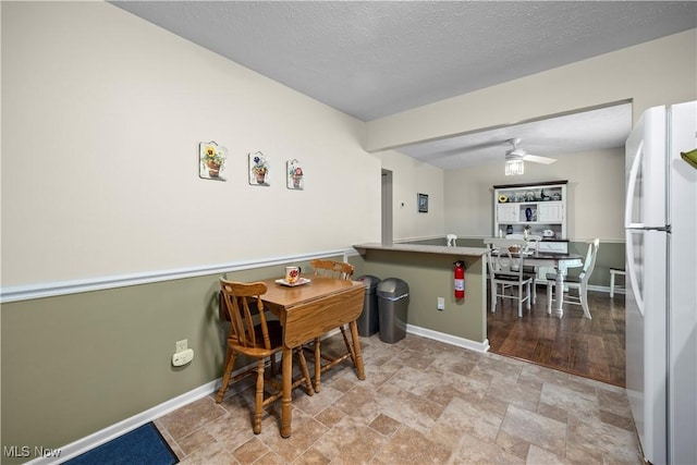 14531 Cross Creek Ln Unit 7, North Royalton, OH 44133 - dining space with stone finish flooring, a ceiling fan, and a textured ceiling