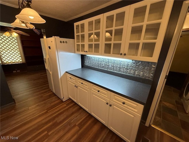 1208 3rd St NW, New Philadelphia, OH 44663 - kitchen with freestanding refrigerator, dark countertops, dark wood-style floors, white cabinetry, and crown molding