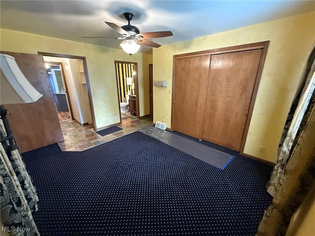 1208 3rd St NW, New Philadelphia, OH 44663 - unfurnished bedroom with stone finish floors, a closet, and a ceiling fan
