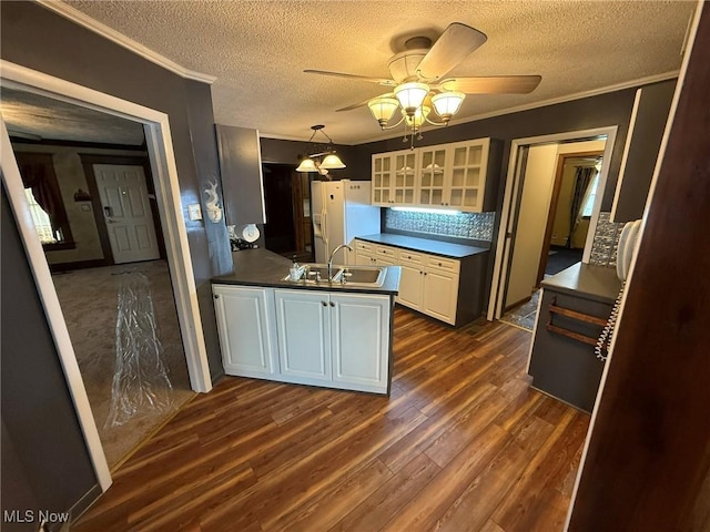 1208 3rd St NW, New Philadelphia, OH 44663 - kitchen with white fridge with ice dispenser, dark wood-style flooring, a textured ceiling, a peninsula, and glass insert cabinets