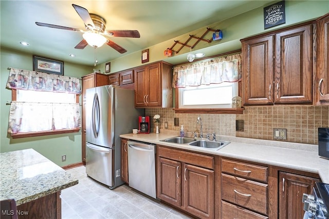 1433 Raleigh Blvd, Copley, OH 44321 - kitchen with stainless steel appliances, a ceiling fan, light countertops, backsplash, and brown cabinetry