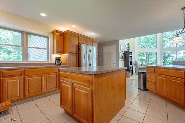 7716 N Ridge Pl, Lisbon, OH 44432 - kitchen with stainless steel fridge, a kitchen island, light tile patterned flooring, brown cabinets, and recessed lighting