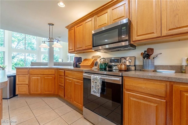 7716 N Ridge Pl, Lisbon, OH 44432 - kitchen with appliances with stainless steel finishes, light tile patterned floors, light countertops, decorative light fixtures, and a peninsula