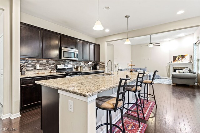 464 Marfa Cir, Copley, OH 44321 - kitchen with stainless steel appliances, dark wood-style flooring, open floor plan, tasteful backsplash, and a kitchen bar