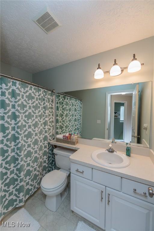 23450 Wainwright Ter, Olmsted Falls, OH 44138 - bathroom with vanity, a textured ceiling, and tile patterned floors