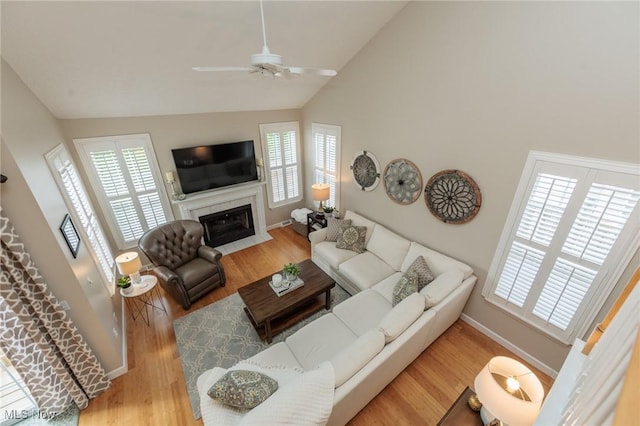23450 Wainwright Ter, Olmsted Falls, OH 44138 - living room with ceiling fan, healthy amount of natural light, wood finished floors, a premium fireplace, and high vaulted ceiling