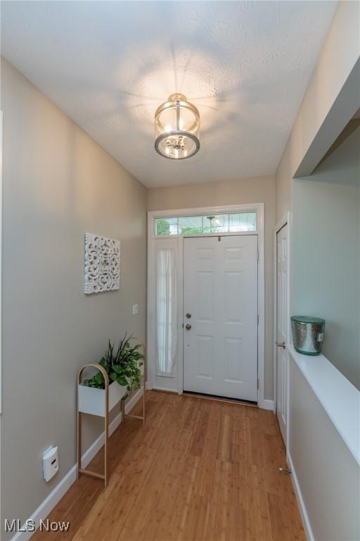 23450 Wainwright Ter, Olmsted Falls, OH 44138 - entryway with light wood-style flooring and a chandelier
