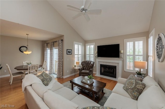 23450 Wainwright Ter, Olmsted Falls, OH 44138 - living room with light wood finished floors, high vaulted ceiling, a ceiling fan, and a tile fireplace
