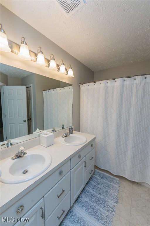 23450 Wainwright Ter, Olmsted Falls, OH 44138 - full bath with double vanity and a textured ceiling