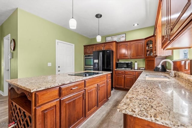 1103 Greenmont Cir, Vienna, WV 26105 - kitchen with black appliances, light wood-style floors, a kitchen island, light stone counters, and glass insert cabinets