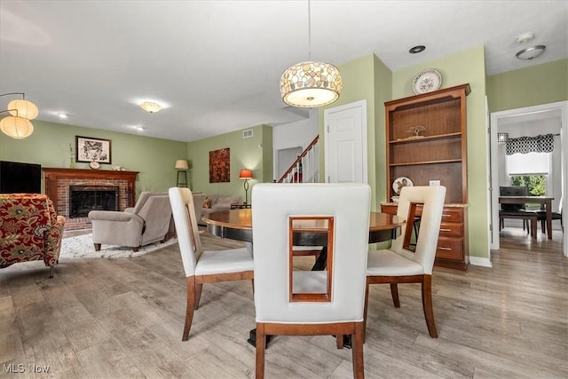 1103 Greenmont Cir, Vienna, WV 26105 - dining area with light wood-style floors, stairway, and a fireplace