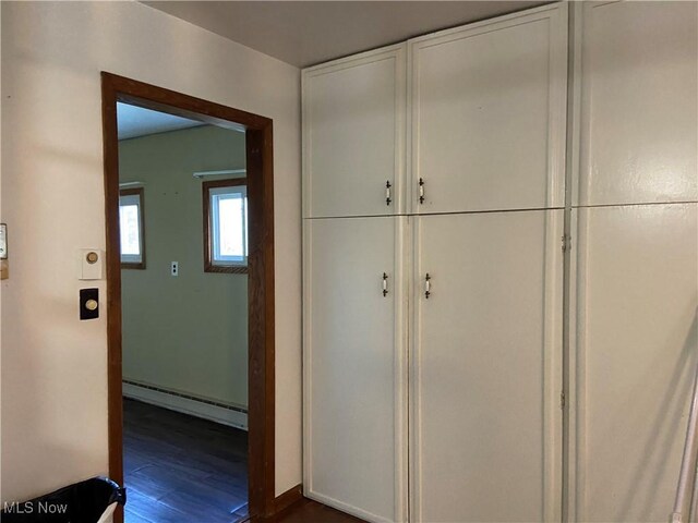 100 Crestview Dr, Newcomerstown, OH 43832 - corridor featuring baseboard heating and dark wood-type flooring