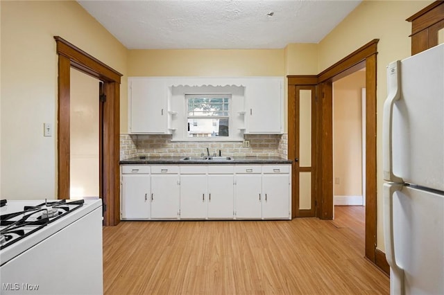 57 Charles Ave, Boardman, OH 44512 - kitchen with white appliances, light wood-type flooring, dark countertops, tasteful backsplash, and white cabinets