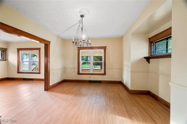 57 Charles Ave, Boardman, OH 44512 - empty room featuring wood finished floors, a chandelier, and healthy amount of natural light