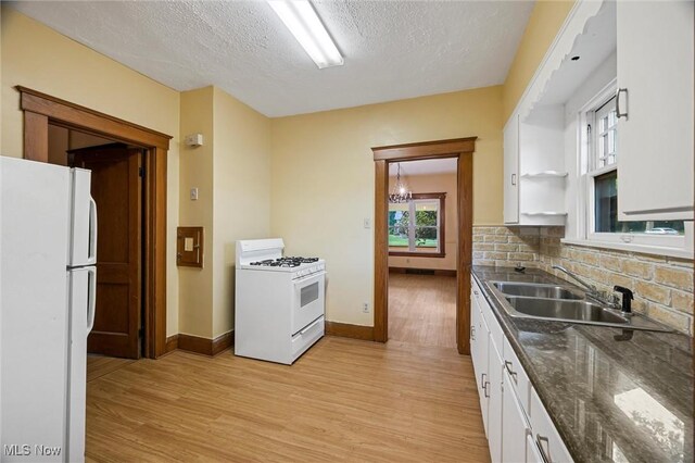 57 Charles Ave, Boardman, OH 44512 - kitchen featuring white appliances, white cabinets, light wood-style floors, a textured ceiling, and tasteful backsplash