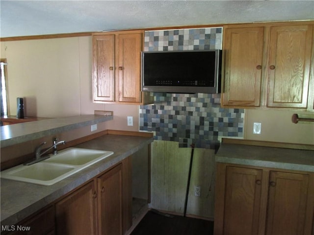 114 Quail Ln, Saint Marys, WV 26170 - kitchen with stainless steel microwave, brown cabinets, and decorative backsplash