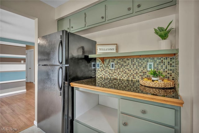 484 E 319th St, Willowick, OH 44095 - kitchen with freestanding refrigerator, green cabinets, tasteful backsplash, and light wood-style flooring