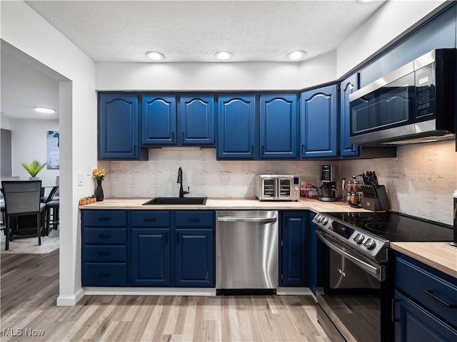1217 W River Rd N Unit A3, Elyria, OH 44035 - kitchen with appliances with stainless steel finishes, blue cabinets, light countertops, light wood-style flooring, and a textured ceiling